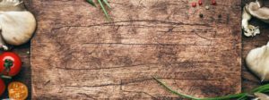 rustic cutting board surrounded by vegetables